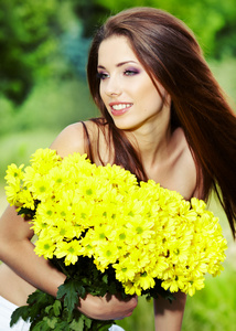 可爱的年轻女孩与黄色的花朵微笑的特写肖像