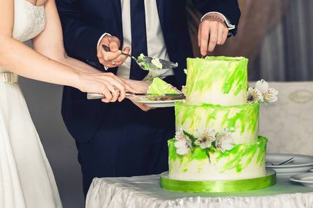 新婚夫妇切开婚礼三层绿色的蛋糕