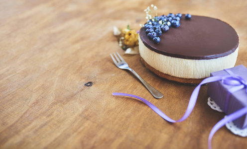 美味的蛋糕与巧克力釉和浆果在木制的乡间餐桌上