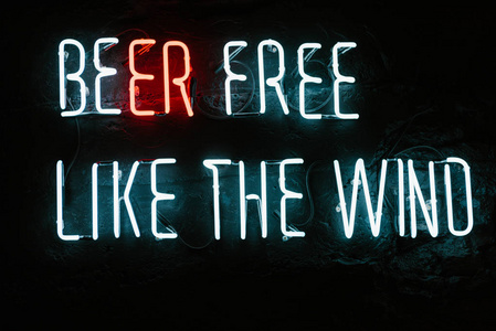 啤酒自由像风霓虹铭文在酒吧的黑暗墙上