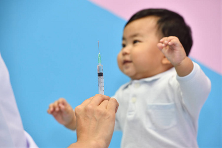 医生为亚洲婴儿在医院拿注射器注射疫苗