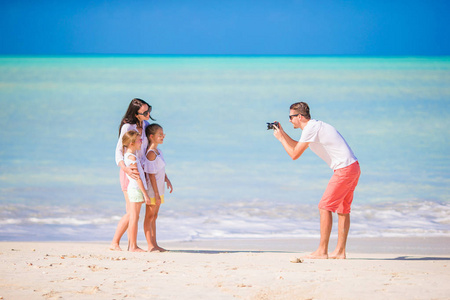 男人在海滩上拍他家人的照片