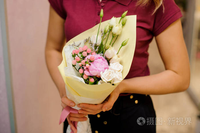 捧着一束玫瑰和牡丹的女孩
