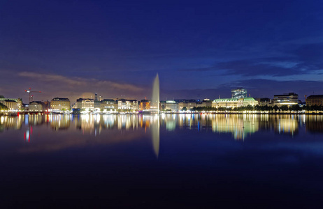 汉堡 Binnenalster 在晚上与 Alsterhaus 和喷泉在背景