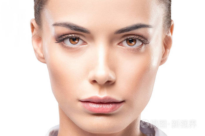 美女在白色的背景下用自然的皮肤贴近女性脸部的肖像看镜头的黑发女性