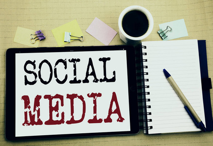 社交媒体。社区社会媒体的商业理念写在平板电脑上, 木制背景与粘纸条, 咖啡和钢笔图片
