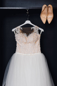 婚礼白色伴娘礼服的衣架上穿紧身衣和米色鞋