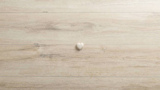 白色的心由石头制成, 躺在 woodenk 桌上