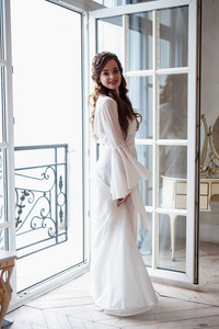 美丽的新娘在白色婚礼 peignoir 在一个早晨。室内美画像