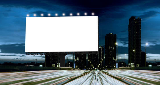 在城市的背景下，与屏幕上的剪切路径与黄昏空白在公路上的广告牌   可以用来显示您的产品或促销