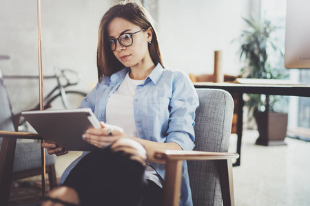 年轻美丽的女学生使用触摸垫在现代 coworking 的地方。自由职业者的女孩工作在她的数码片