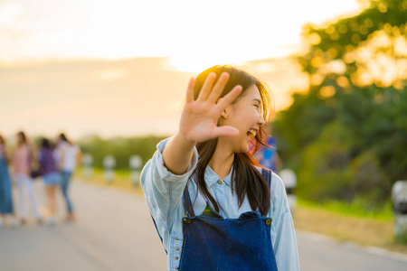 亚洲青少年女孩提高她的右臂, 高兴地向前