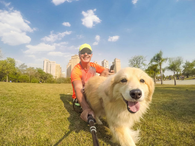 一个人的狗宠物狗看着相机与它的主人在一个城市公园.