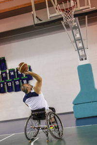 残疾人运动男子在打室内篮球时的行动