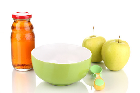 婴儿板和勺子与苹果和孤立在白色的汁