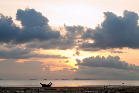 夕阳与船在海面，多云的天空