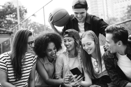 微笑时尚的年轻朋友使用智能手机户外在街头, 黑白
