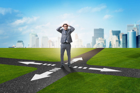 不确定概念交叉路口的年轻商人图片