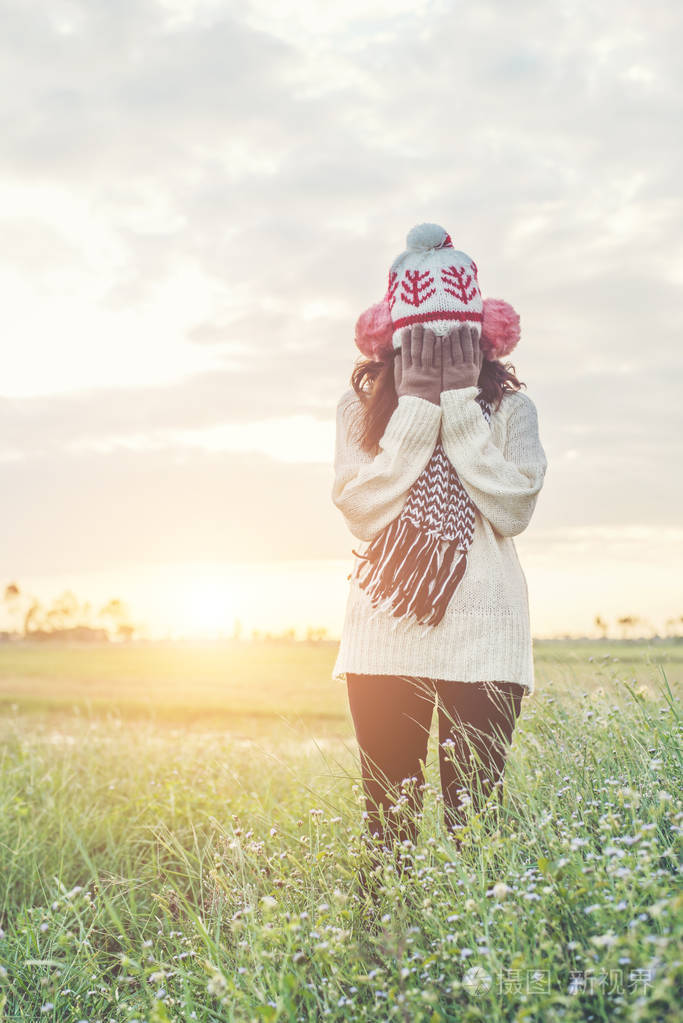 太阳下站在田野上孤独的女人的剪影