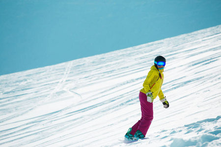 运动妇女的照片穿着 ahelmet 和面具, 滑雪从山坡上