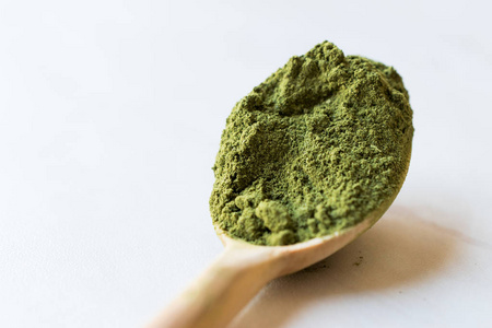 绿旳茶粉配木勺和玻璃碗咖啡厅的冰配拿铁绿茶杯绿茶旳拿铁艺术与多汁