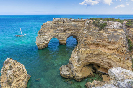 岩石峭壁拱门上 Marinha 海滩和绿松石海水对海岸的葡萄牙阿尔加维地区