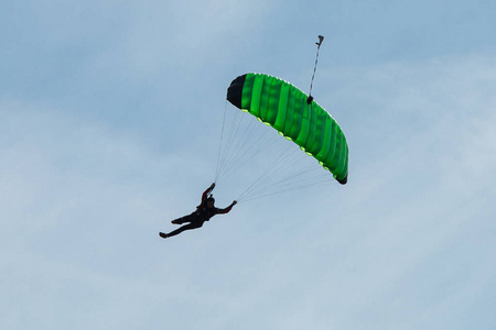 伞兵绿色降落伞对抗清澈的蓝天