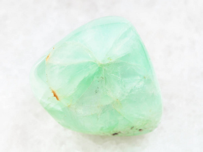 在白色大理石上暴跌的 Prehnite 宝石