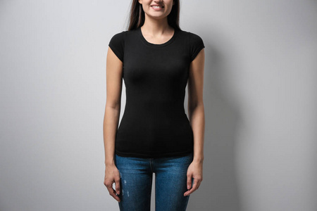 在浅色背景的黑色 t恤衫的女人。模拟设计