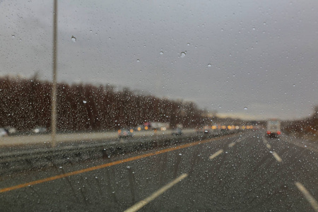 雨点落在玻璃上在模糊的图像中水滴在汽车玻璃上