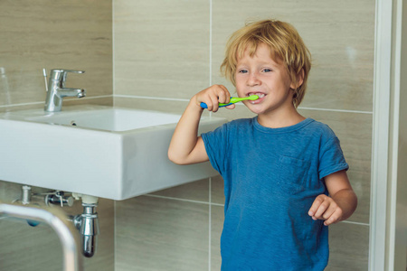 小金发男孩在家用浴缸里学习刷牙。学习如何保持健康的孩子。医疗保健理念
