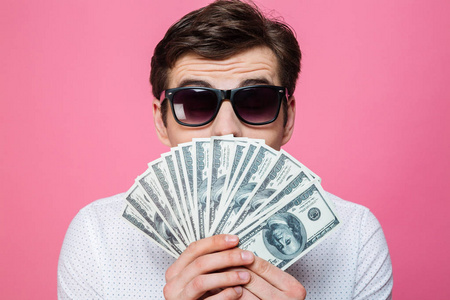 年轻人拿着钱盖脸照片