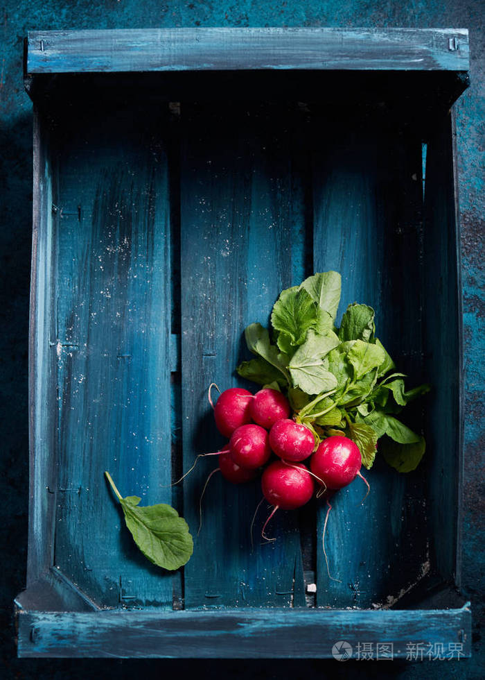 深蓝色木箱中鲜红色萝卜特写照片