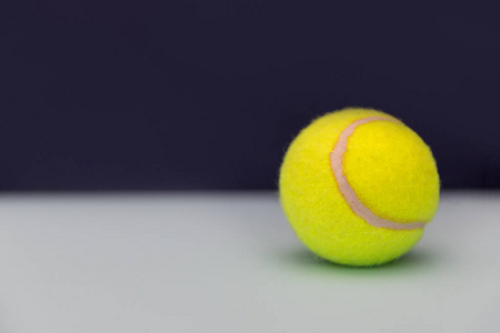 灰色桌上的黄色网球球, 在黑暗背景下