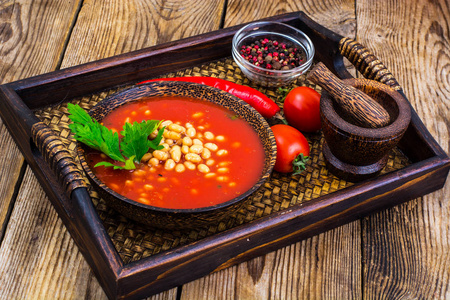 红色乌克兰罗宋汤木托盘上的白豆。特写。营养概念