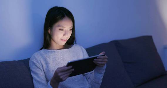 女人在晚上使用平板电脑