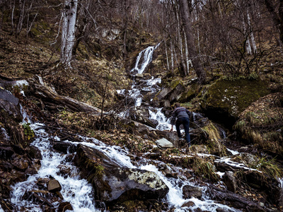 在瀑布附近的森林里散步的年轻人