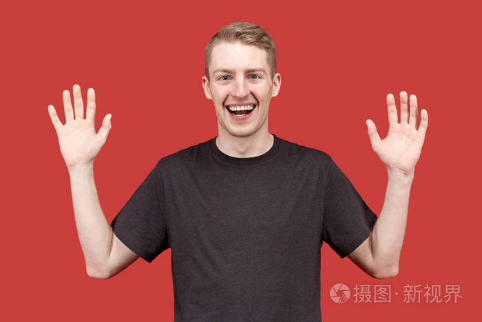 欢乐快乐的年轻人举起双手在投降的姿势笑并喜欢会见朋友