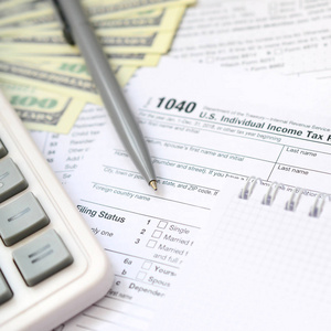 钢笔, 笔记本, 计算器, 和美元是在税形式1040美国个人所得税回归。纳税时间