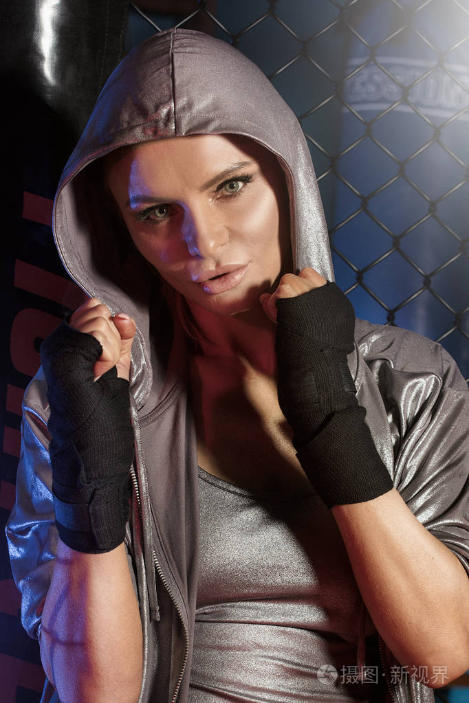 女拳击手在拳击笼里摆姿势