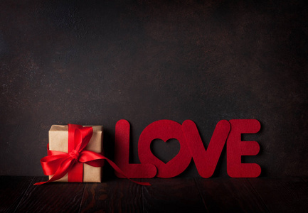 情人节贺卡用爱词和礼物箱子在黑板。与空间