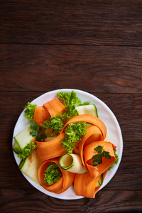 艺术性地服务菜沙拉与胡萝卜, 黄瓜, letucce 在木背景, 选择性焦点