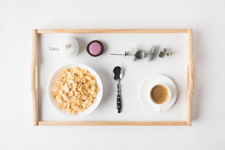 顶部的早餐与软木片在碗和咖啡杯的托盘上的白色表面