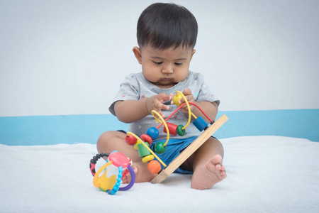 可爱的小亚洲婴儿玩木制玩具