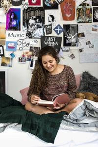 十几岁的女孩读一本书在卧室里
