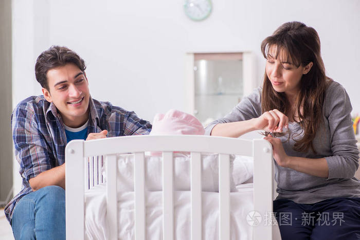 年轻的父母与他们的新生儿婴儿床附近照片-正版商用图片043n5c-摄图新