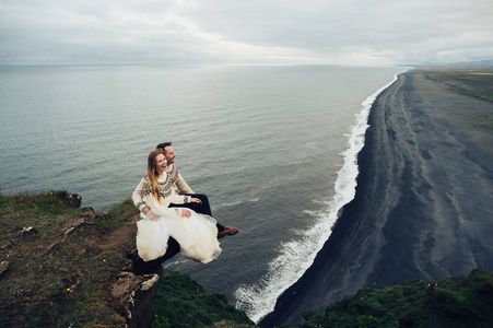 坐在悬崖上的一对夫妇在毛衣