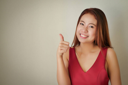 快乐正面成功接受妇女显示拇指姿态, 亚洲女性模型