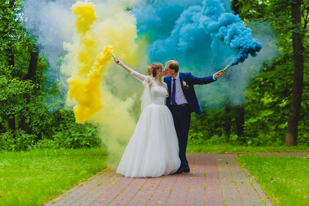 新娘和新郎用五颜六色的烟雾