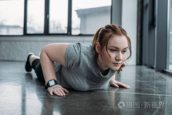 肥胖女孩在健身房做俯卧撑